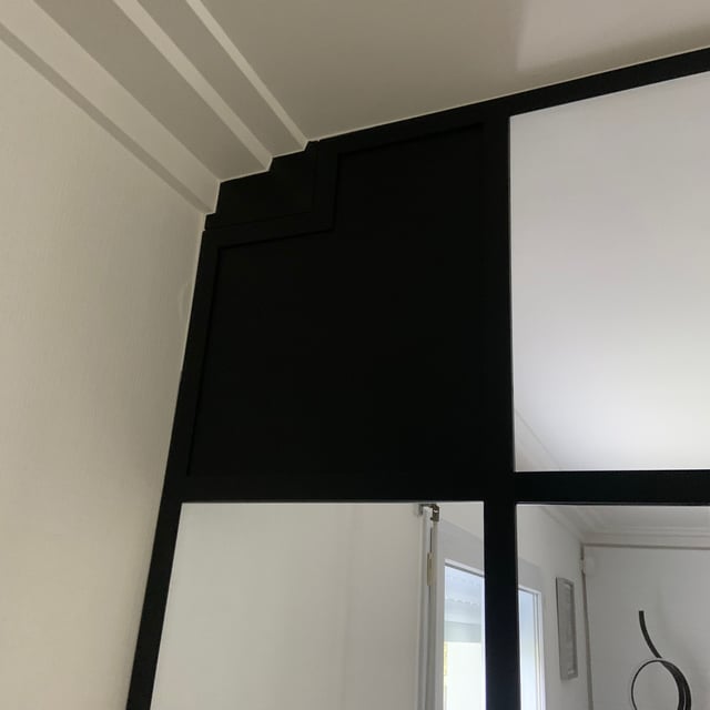Verrière d'intérieur toute hauteur laissant passer la lumière dans le salon
