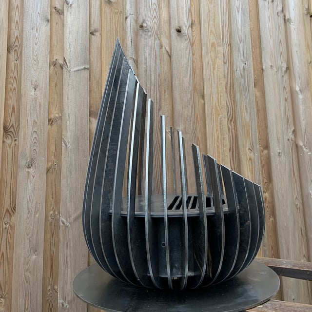 Brasero corten allumé offrant un feu chaleureux et une surface de cuisson