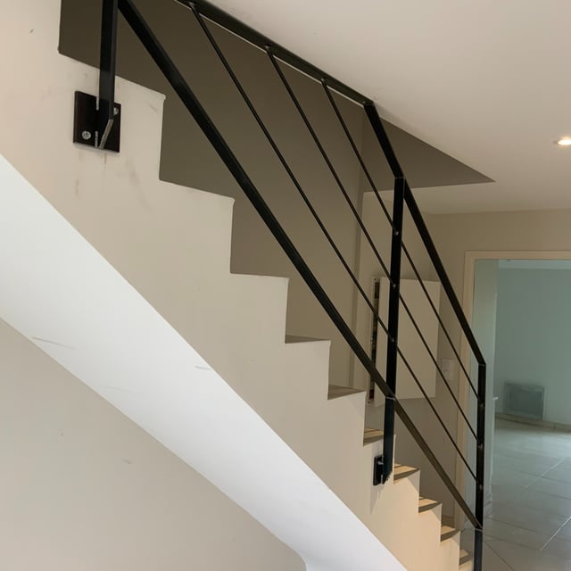 Garde-corps acier brut verni posé sur un escalier béton dans le Morbihan